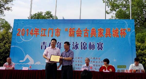 新會區(qū)體育局局長劉樹高給廣東新會古典家具城有限公司頒發(fā)“真情助競賽，愛心育棟梁”紀念牌匾 