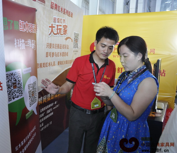 中國古典家具網(wǎng)、《品牌紅木》雜志工作人員正在協(xié)助參展者參加“超級紅木大玩家”活動