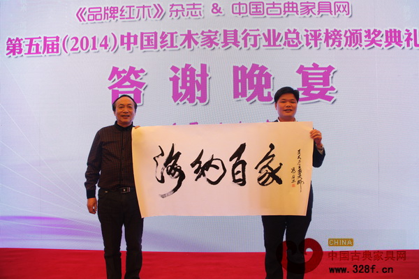 馮文土大師（左）的墨寶“海納百家”被中山偉明軒紅木董事長(zhǎng)張石乃（右）拍得