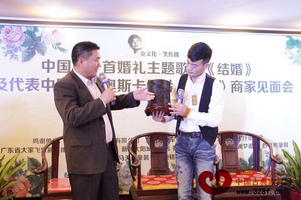 唐明居紅木董事長胡高華向劉金笑導(dǎo)演贈送小葉紫檀絲翎檀雕筆筒