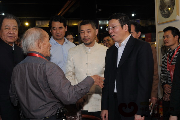 中山市常務副會長謝中凡（右）與交易會上的工藝美術大師交流