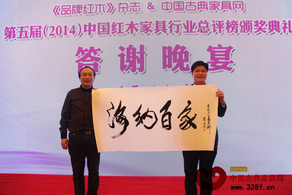 愛好書法的張石乃在第五屆紅木總評榜頒獎典禮答謝晚宴上，拍得亞太地區(qū)手工藝大師、中國工藝美術(shù)大師馮文土墨寶《海納百家》