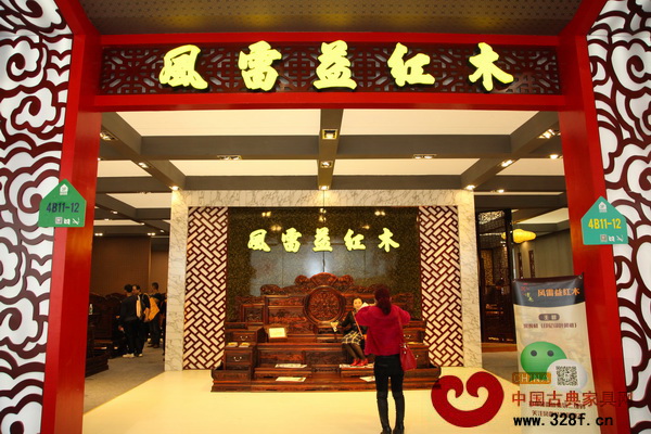 消費(fèi)者坐在風(fēng)雷益紅木的參展作品上拍照留念 消費(fèi)者坐在風(fēng)雷益紅木的參展作品上拍照留念