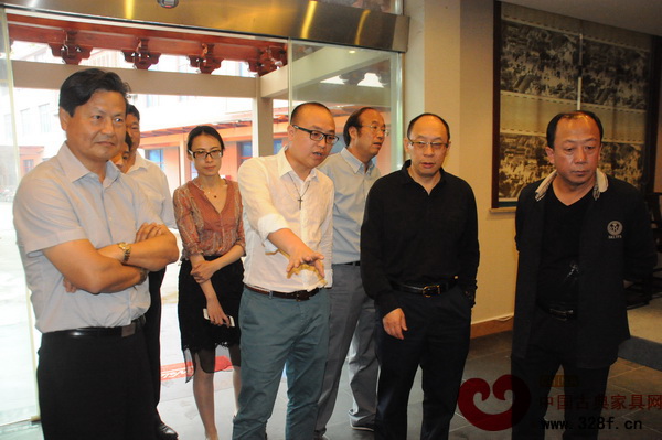 卓木王紅木總經(jīng)理杜長江（右四）向參觀嘉賓介紹卓木王紅木家具