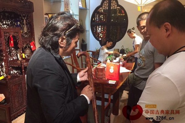 戴為紅木總裁戴愛國向客人介紹黃花梨手杖的獨(dú)特紋理 戴為紅木總裁戴愛國向客人介紹黃花梨手杖的獨(dú)特紋理