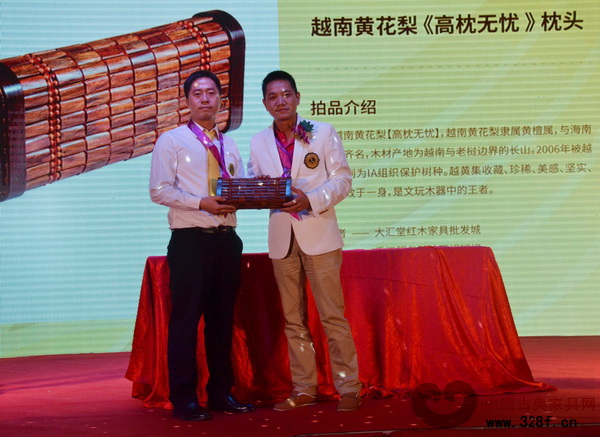 慈善晚宴上，大匯堂紅木總經(jīng)理胡春龍（左）與最終拍得由大匯堂紅木捐贈的越南黃花梨《高枕無憂》枕頭的獅友合影