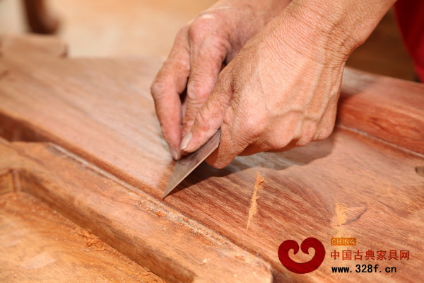 雅仕軒紅木的工人對家具進(jìn)行刮磨