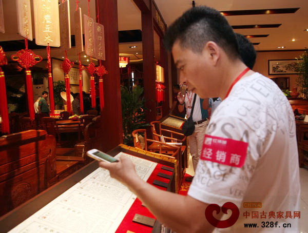 一名經(jīng)銷商正在用相機拍攝某品牌紅木家具詳細介紹 一名經(jīng)銷商正在用相機拍攝某品牌紅木家具詳細介紹
