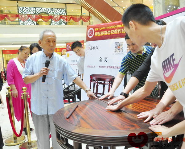 故宮家具修復(fù)專家、古典家具傳承工藝大師王秀林請消費者通過觸摸感受《大紅酸枝·明式枕環(huán)月牙桌》的精湛工藝 故宮家具修復(fù)專家、古典家具傳承工藝大師王秀林請消費者通過觸摸感受《大紅酸枝·明式枕環(huán)月牙桌》的精湛工藝