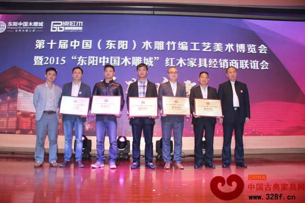 2015“東陽中國木雕城”紅木家具經(jīng)銷商聯(lián)誼會答謝晚宴上,品牌紅木家具經(jīng)銷商聯(lián)盟執(zhí)行主席石立峰(右一)和品牌紅木家具經(jīng)銷商聯(lián)盟發(fā)起人、弘木傳媒CEO林偉華(左一)為協(xié)辦單位蘇陽紅(左三)頒牌 2015“東陽中國木雕城”紅木家具經(jīng)銷商聯(lián)誼會答謝晚宴上,品牌紅木家具經(jīng)銷商聯(lián)盟執(zhí)行主席石立峰(右一)和品牌紅木家具經(jīng)銷商聯(lián)盟發(fā)起人、弘木傳媒CEO林偉華(左一)為協(xié)辦單位蘇陽紅(左三)頒牌