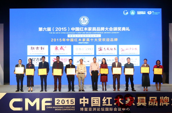 興成紅木總經(jīng)理張靜怡(右一)上臺接受“2015年中國紅木家具十大受歡迎品牌”頒獎 興成紅木總經(jīng)理張靜怡(右一)上臺接受“2015年中國紅木家具十大受歡迎品牌”頒獎
