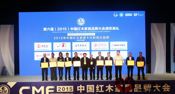 上海老周紅木六度蟬聯(lián)“中國紅木家具十大影響力品牌”董事長周仲堅(jiān)(右一)上臺領(lǐng)獎(jiǎng)