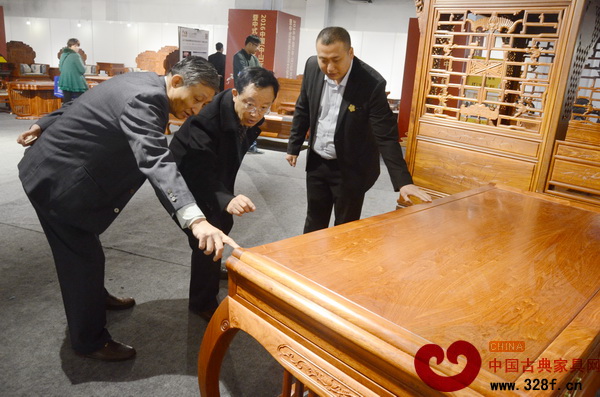 原故宮博物院文?？萍疾恐魅尾莒o樓（左）、華南林業(yè)大學(xué)博士生導(dǎo)師李凱夫（中）對(duì)《緬甸花梨靈秀辦公臺(tái)》進(jìn)行細(xì)致的點(diǎn)評(píng)