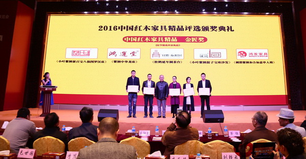 原故宮家具修復(fù)專家王秀林（左三）為鴻運堂總經(jīng)理蕭耀能（左二）頒發(fā)“中國紅木家具精品金匠獎”獲獎證書