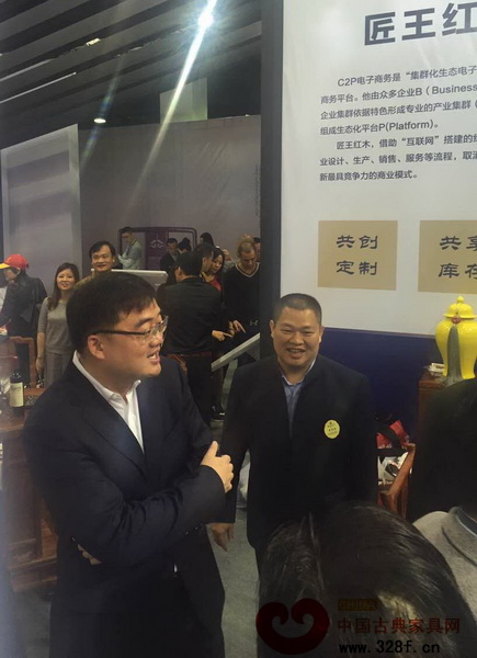 東陽市委書記黃敏(左)參觀匠王紅木東陽紅博會的展廳,匠王紅木董事長李茂先為其介紹匠王紅木C2P模式 東陽市委書記黃敏(左)參觀匠王紅木東陽紅博會的展廳,匠王紅木董事長李茂先為其介紹匠王紅木C2P模式