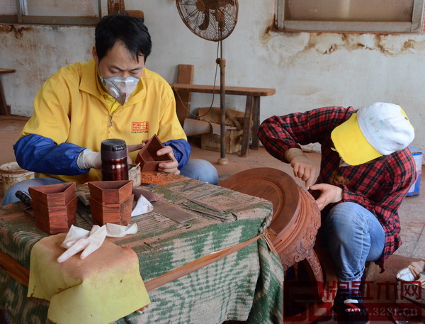 打磨車間，武大姐和王大哥，一個在打磨糖果盒，一個在打磨鼓凳