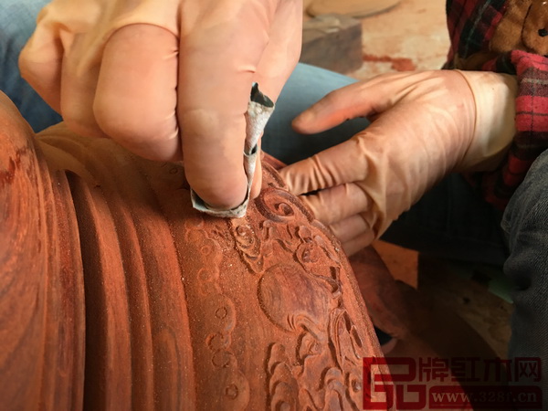 武大姐用砂紙細細打磨鼓凳的雕花