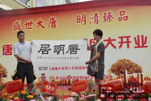 中國著名書法姜以寧（夫人代，右）向唐明居健康家居館贈送書法墨寶