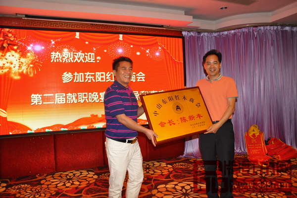 大涌鎮(zhèn)黨委書記黃紅全（右）為中山東陽紅木商會會長、長豐紅木董事長陳新豐頒發(fā)會長牌匾