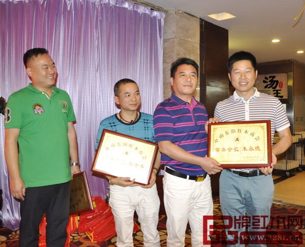 中山東陽紅木商會會長、長豐紅木董事長陳新豐(右二)為朱永德(右一)頒發(fā)獎(jiǎng)牌 中山東陽紅木商會會長、長豐紅木董事長陳新豐(右二)為朱永德(右一)頒發(fā)獎(jiǎng)牌