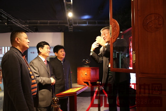 志成紅木董事長李正倫（左一）與總經(jīng)理湯朝陽（右一）共同為中國家具協(xié)會(huì)理事長朱長嶺（左二）、大涌鎮(zhèn)黨委委員謝巧明（右二）介紹智能紅木家具