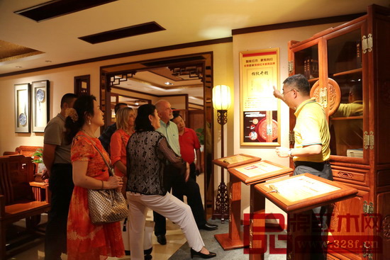 志成紅木總經(jīng)理湯朝陽(yáng)（右一）為外國(guó)友人們?cè)敿?xì)介紹志成紅木智能家具鎖工藝特點(diǎn)