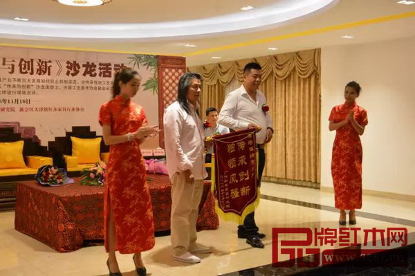 居典紅木董事長尹付林向伍炳亮大師送上“傳承創(chuàng)新，獨(dú)領(lǐng)風(fēng)騷”的錦旗