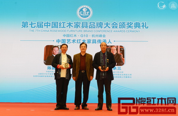 全國(guó)政協(xié)常委、全國(guó)工商聯(lián)原常務(wù)副主席孫安民（中）為“中國(guó)藝術(shù)紅木家具傳承人”獲獎(jiǎng)?wù)撸|莞國(guó)壽紅木董事長(zhǎng)陳國(guó)壽、東陽(yáng)卓木王紅木董事長(zhǎng)杜承三）頒牌