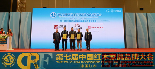 全國(guó)工商聯(lián)民間文物藝術(shù)品商會(huì)秘書(shū)長(zhǎng)肖秉俠（右一）、東北林業(yè)大學(xué)明清家具研究所所長(zhǎng)牛曉霆（左一）為“2016年中國(guó)紅木家具特具影響力專(zhuān)業(yè)市場(chǎng)”獲獎(jiǎng)?wù)撸ㄖ袊?guó)（大涌）紅木文化博覽城、新會(huì)古典家具城、濟(jì)南富雅紅木樓）頒牌