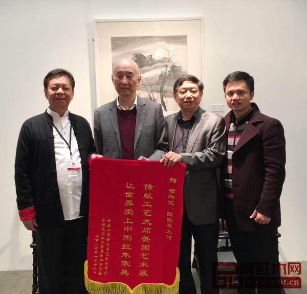 全國(guó)工商聯(lián)執(zhí)委、全聯(lián)民間文物藝術(shù)品商會(huì)會(huì)長(zhǎng)宋建文（右二），全聯(lián)藝術(shù)紅木家具專委會(huì)執(zhí)行會(huì)長(zhǎng)林偉華（右一）為兩位中國(guó)傳統(tǒng)工藝大師邵湘文（左二）、陳國(guó)壽（左一）贈(zèng)送紀(jì)念錦旗