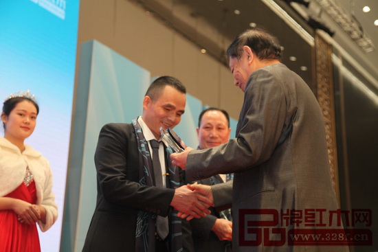 全國工商聯(lián)執(zhí)委、全聯(lián)民間文物藝術(shù)品商會會長宋建文為雅仕軒董事長陳君頒發(fā)“2016年中國紅木家具十大風(fēng)云企業(yè)家”獎杯