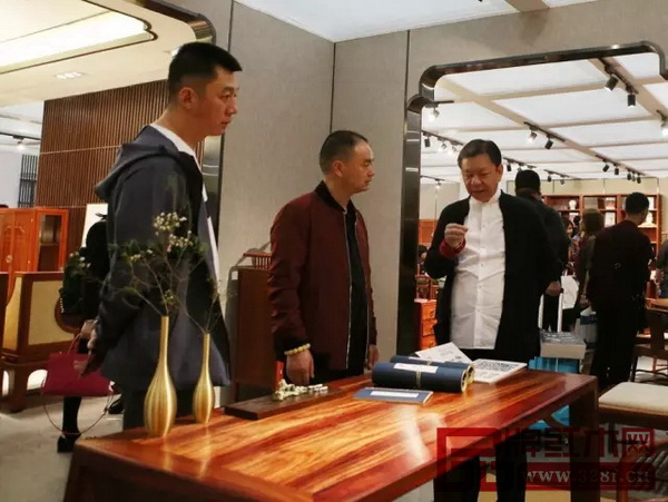 國壽紅木董事長陳國壽（右一）為經(jīng)銷商點(diǎn)評(píng)參評(píng)作品“桃源陋室”設(shè)計(jì)精髓