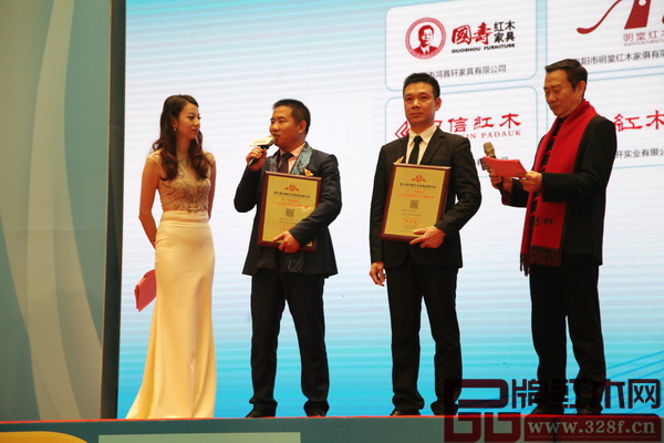 老周紅木榮獲“第七屆中國紅木家具十大影響力品牌”，董事長周仲堅(jiān)（右一）上臺(tái)領(lǐng)獎(jiǎng)