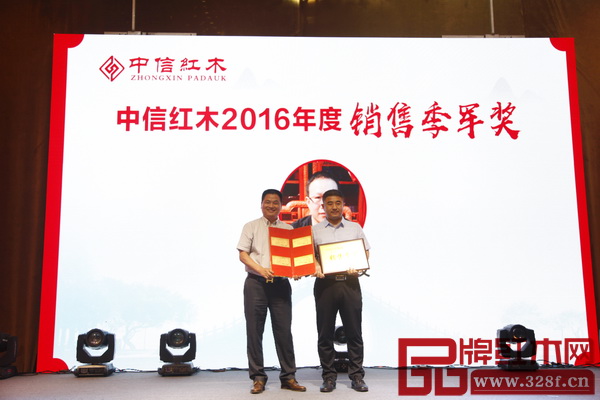 中信紅木董事長(zhǎng)李忠信（左）為“中信紅木2016年度銷售季軍”獲獎(jiǎng)?wù)哳C獎(jiǎng)