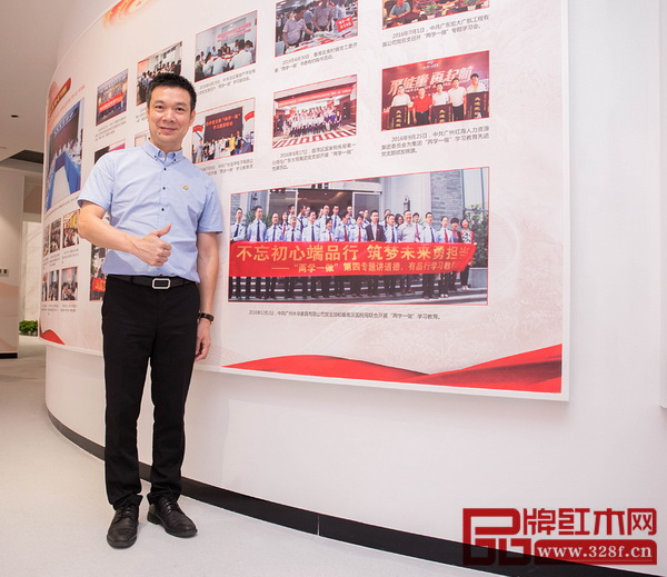 永華紅木黨支部活動剪影被收錄在非公有制經(jīng)濟(jì)組織黨建工作展覽館，黨支部書記邱志坤在剪影前留念