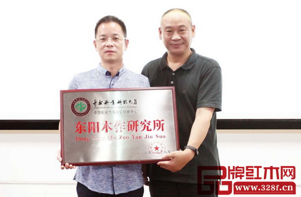 中南林業(yè)科技大學(xué)教授、家具學(xué)院院長劉文金(右)為純本森活董事長厲清平頒發(fā)“東陽木作研究所”牌匾 中南林業(yè)科技大學(xué)教授、家具學(xué)院院長劉文金(右)為純本森活董事長厲清平頒發(fā)“東陽木作研究所”牌匾