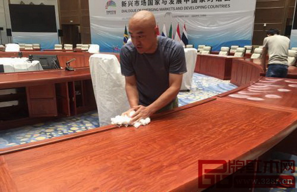 會議現(xiàn)場工作人員在擦拭紅木家具