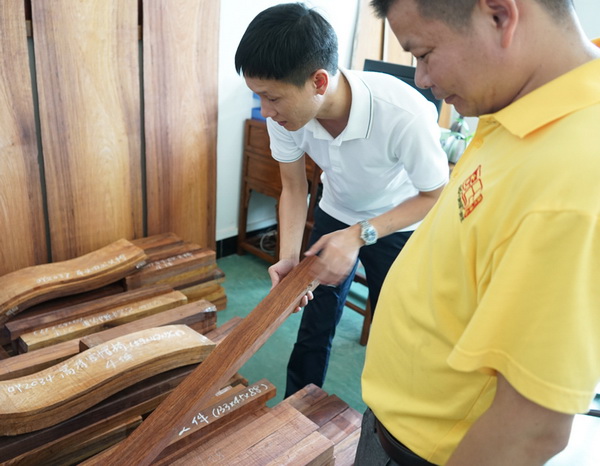 區(qū)氏臻品總經(jīng)理區(qū)錦澤(左)與工匠一同嚴把黃花梨選料 區(qū)氏臻品總經(jīng)理區(qū)錦澤(左)與工匠一同嚴把黃花梨選料