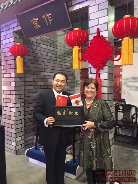 太和木作董事長關(guān)毅先生（左）向加拿大前副總理希拉·科普斯女士贈送“太和充滿”故宮微型匾額