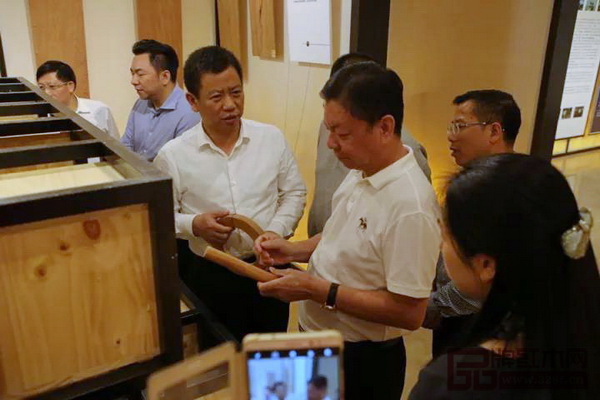 中國傳統(tǒng)工藝大師、國壽紅木董事長陳國壽（右二）為桂陽縣委書記彭生智（左三）介紹紅木家具特有的榫卯結構