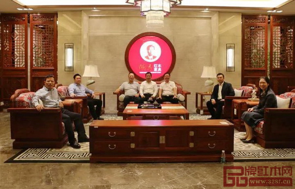 考察團一行人落座在國壽紅木家具上合影留念