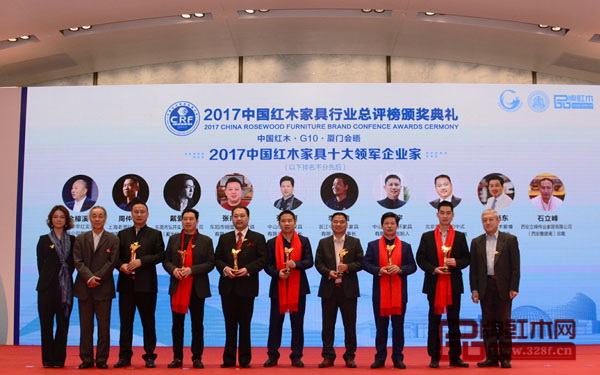 中國(guó)明式家具研究所原所長(zhǎng)濮安國(guó)（左二）、全聯(lián)民間文物藝術(shù)品商會(huì)會(huì)長(zhǎng)助理肖秉俠（右一）為“2017中國(guó)紅木家具十大領(lǐng)軍企業(yè)家”獲獎(jiǎng)?wù)哳C發(fā)獎(jiǎng)杯