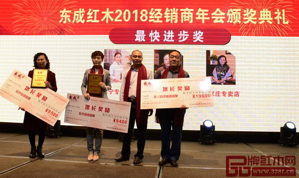 東成紅木生產(chǎn)廠長吳建清（右二）為獲得“最快進(jìn)步獎(jiǎng)”的經(jīng)銷商頒獎(jiǎng)