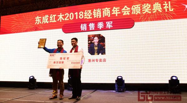 東成紅木營銷副總經(jīng)理曾東陽（右）為獲得“銷售季軍”經(jīng)銷商頒獎(jiǎng)