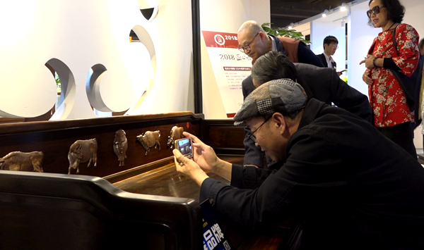 全聯(lián)藝術(shù)紅木家具專業(yè)委員會(huì)專家顧問團(tuán)在現(xiàn)場為伍氏大觀園《老撾大紅酸枝五牛圖羅漢床》評(píng)分