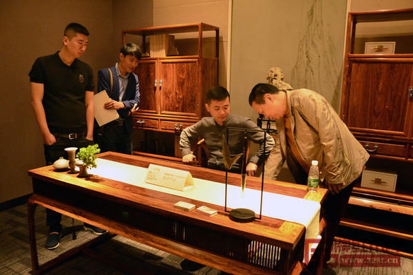 紅寶軒董事長曹兆庭（右一）親自為經(jīng)銷商介紹“玉系列”新品的“呼吸工藝”