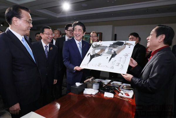 故宮文創(chuàng)展上，眾人圍繞純本森活畫案正在欣賞北京奧運會吉祥物福娃設(shè)計者韓美林（右一）畫作