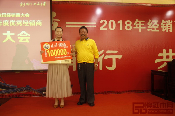  在明清居2017優(yōu)秀經(jīng)銷商表彰大會(huì)上，董事長金彪云（右）為獲獎(jiǎng)經(jīng)銷商頒獎(jiǎng)