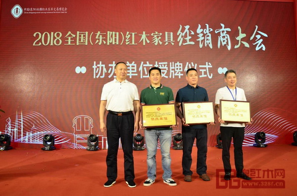 全聯(lián)藝術(shù)紅木家具專業(yè)委員會(huì)主席團(tuán)主席、西安雅居閣總裁石立峰（左一）為本次大會(huì)協(xié)辦單位浙江藝術(shù)紫檀博物館（右一）、興成紅木（右二）、簡(jiǎn)悟家居（左二）代表授牌