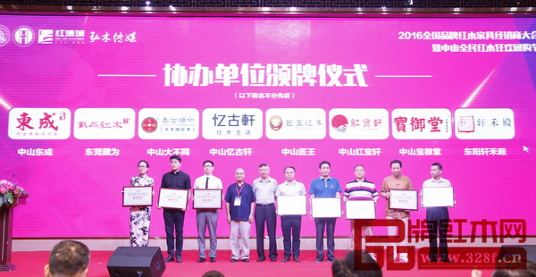 全國(guó)工商聯(lián)執(zhí)委、全聯(lián)民間文物藝術(shù)品商會(huì)會(huì)長(zhǎng)宋建文（左五），中國(guó)高等家具設(shè)計(jì)專業(yè)創(chuàng)始人、中南林業(yè)科技大學(xué)博士生導(dǎo)師胡景初（左四）為寶御堂紅木（右一）頒發(fā)協(xié)辦單位牌匾 